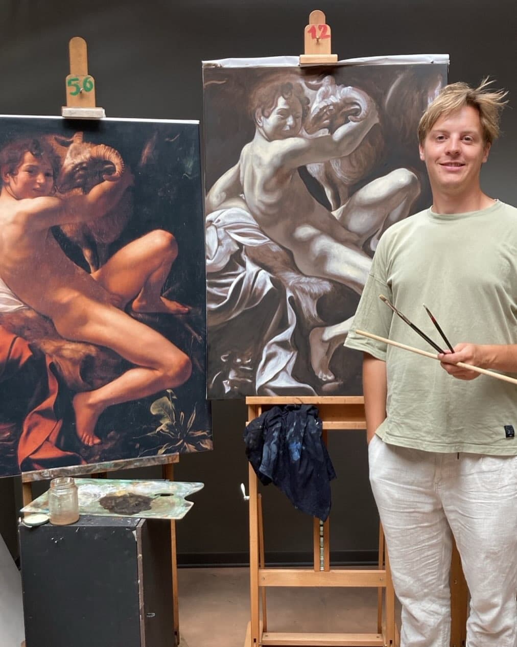 Jelle van de Ridder in zijn atelier met penselen naast twee olieverfschilderijen